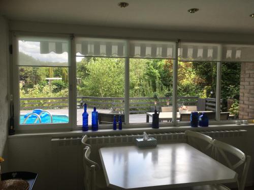 a kitchen window with blue bottles on a table at Holiday Home 'Beautifull Water' in Lanaken
