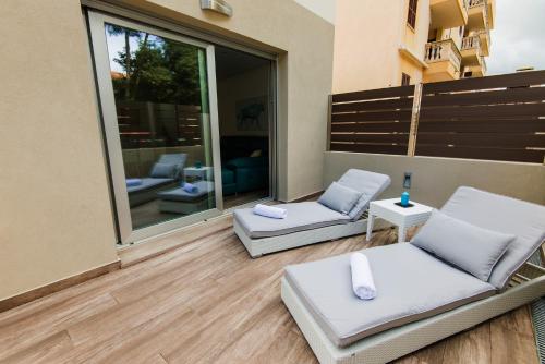 balkon z 2 białymi krzesłami i oknem w obiekcie Villa Can Nieves w Cala Ratjada