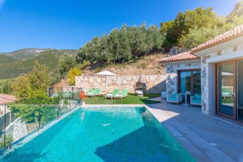 a villa with a swimming pool and a house at Salvator Villas & Spa Hotel in Parga