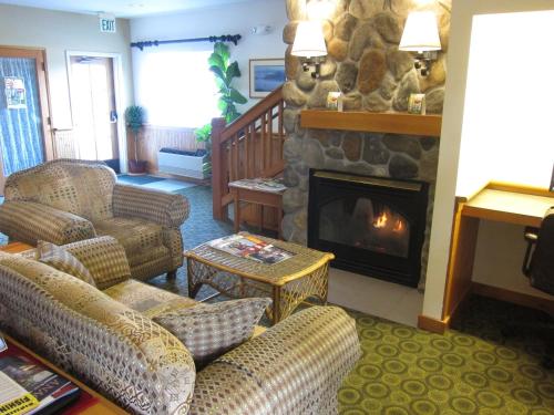 a living room with couches and a stone fireplace at Fidalgo Country Inn in Anacortes