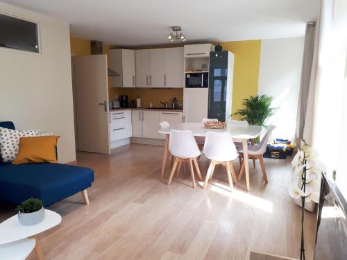 a kitchen and a living room with a table and chairs at Appartement 60m2 / Hyper Centre (Gares et Vieux Lille) in Lille