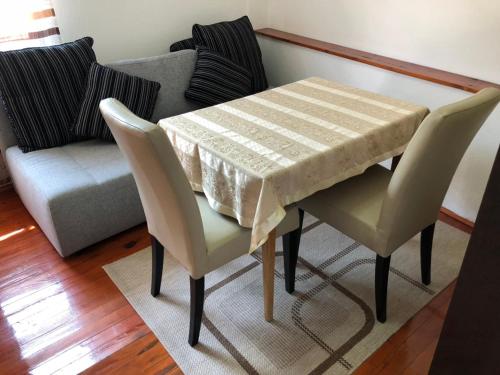 a table and chairs in a living room with a couch at Peace in Vranje