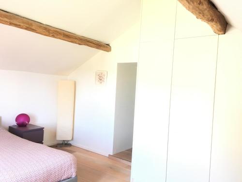 a bedroom with white walls and a bed at L'inspiration in Stavelot