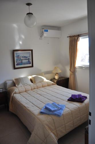 a bedroom with a large bed with two towels on it at Departamento de alquiler temporario in Villa Carlos Paz