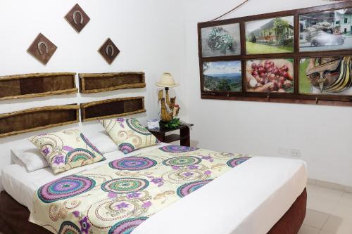 a bedroom with a bed with a colorful comforter at Hotel Zandu in Pereira