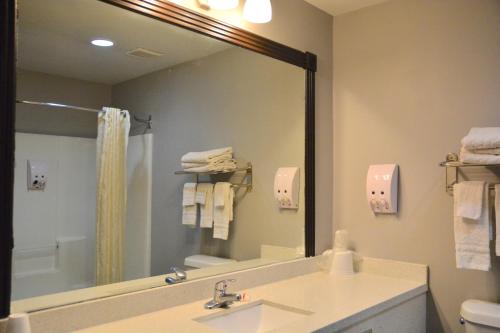 a bathroom with a sink and a large mirror at Blue Bay Inn and Suites in South Padre Island