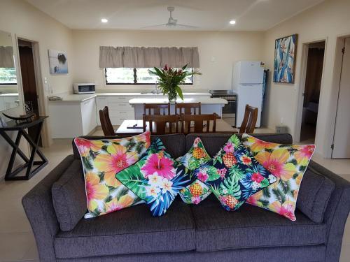 a living room with a couch with pillows on it at Cook Islands Holiday Villas - Turangi Lagoon in Muri