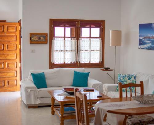 a living room with a white couch and a table at Ayfa Apartment in Punta de Mujeres