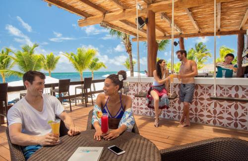 un grupo de personas sentadas en una mesa en un restaurante en Hideaway at Royalton Riviera Cancun, An Autograph Collection All- Inclusive Resort - Adults Only, en Puerto Morelos