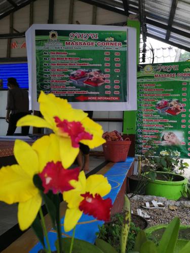 a table with flowers in front of a sign at Yuyu Golden Beach in Ko Chang