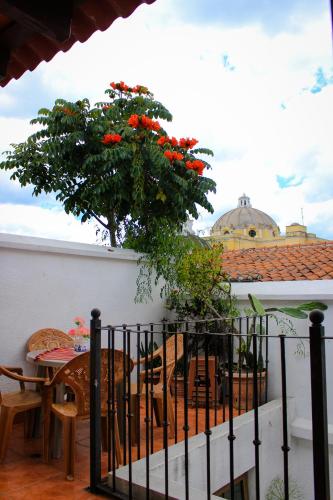 a balcony with a tree with red flowers on it at Hotel Real Antigua in Antigua Guatemala