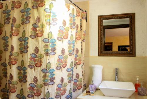 a bathroom with a shower curtain and a sink at Hotel Real Antigua in Antigua Guatemala