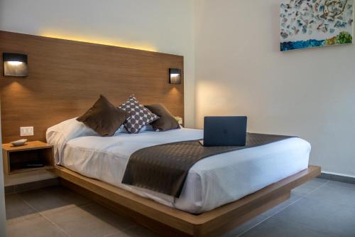 a bedroom with a bed with a laptop on it at Viento Suites Cancún in Cancún