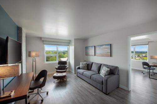 a living room with a couch and a table and chairs at Hotel Interurban Seattle Airport SeaTac in Tukwila