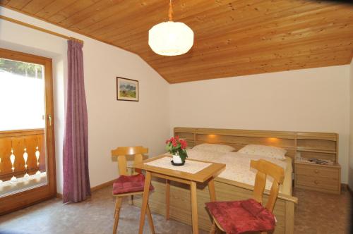 a bedroom with a bed and a table and chairs at Fiziderhof in Castelrotto