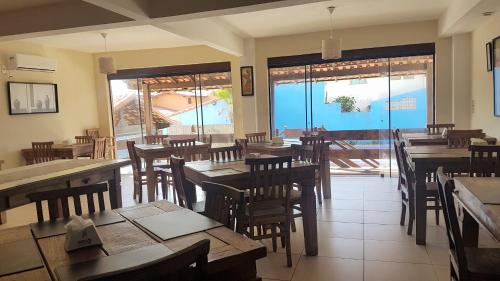 a restaurant with wooden tables and chairs and a patio at Pousada do Albatroz in Cabo Frio