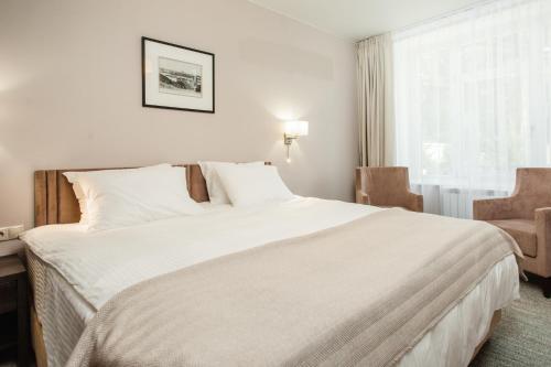 a bedroom with a large white bed and a window at Park Hotel Burduguz in Burduguz