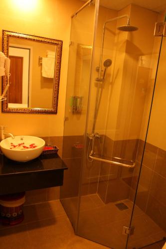 a bathroom with a glass shower and a sink at Dalat Luxury Hotel in Da Lat