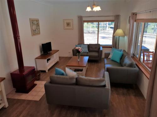 a living room with couches and a coffee table at Woodlane Cottages Hunter Valley in Lovedale