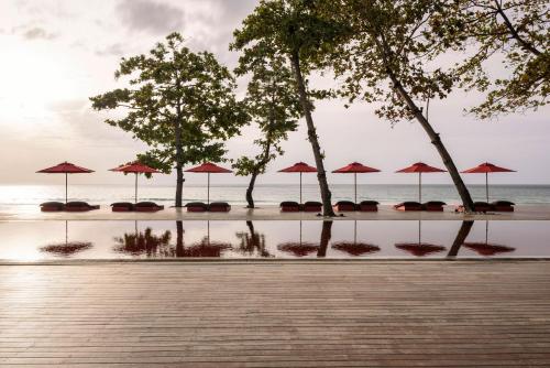 a group of umbrellas on a beach with the ocean at The Secret Pool Villas By The Library Koh Samui in Chaweng