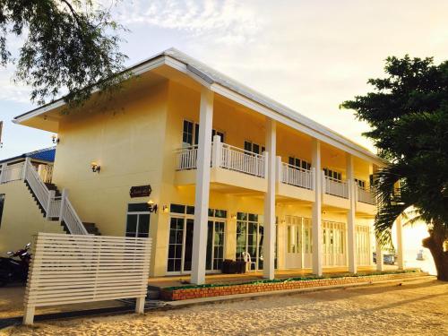 a large yellow building with white columns at Ananda Villa - SHA Plus in Koh Tao