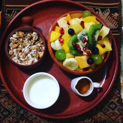a plate of food with two bowls of fruit and a drink at La Casa de Zarela in Huaraz