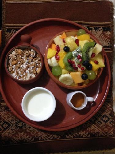 a plate of food with a bowl of fruit and nuts at La Casa de Zarela in Huaraz