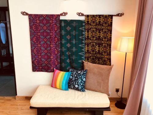 a bench with pillows on it in a room at Ambong Rainforest Retreat in Pantai Cenang