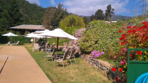 a group of chairs and umbrellas in a garden at Refugios Olmue Santa Teresa in El Maqui