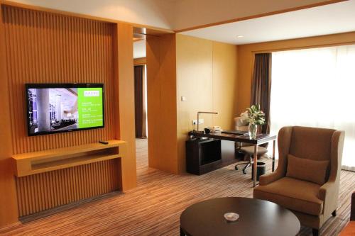 a hotel room with a television and a desk in a room at Holiday Inn Shijiazhuang Central by IHG in Shijiazhuang