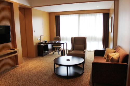 a living room with a couch and a table in a hotel room at Holiday Inn Shijiazhuang Central, an IHG Hotel in Shijiazhuang