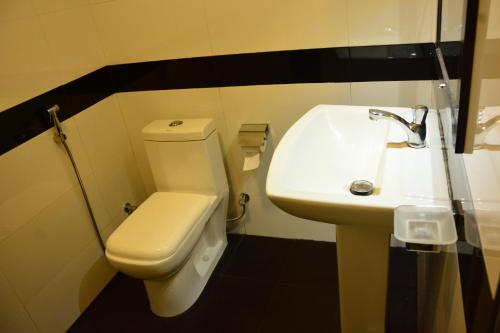 a bathroom with a white toilet and a sink at Eagle Wings Holiday in Belihul Oya