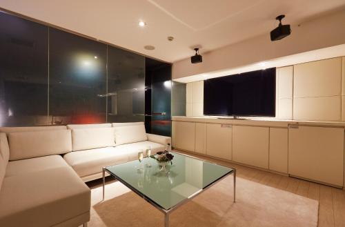 a living room with a white couch and a glass table at HOTEL LOVE in Nagoya