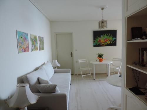 Biały salon z kanapą i stołem w obiekcie Seafront w mieście Karistos