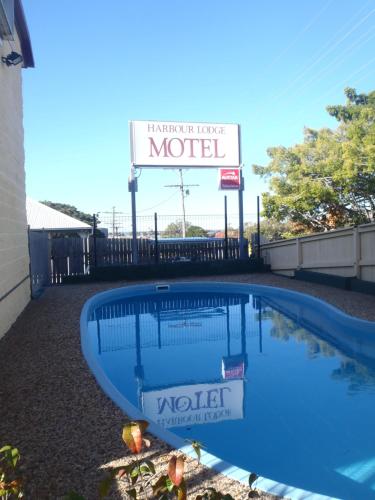 a blue and white swimming pool with a sign on it at Harbour Lodge Motel in Gladstone