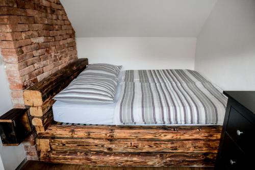 a bed in a room next to a brick wall at ABC apartments in Kamnik