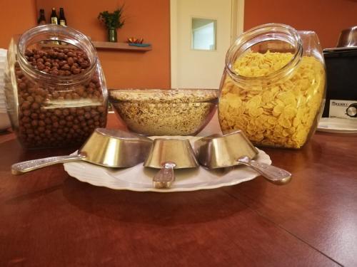 a table with three glass jars and bowls of food at Ambient Hotel in Domžale