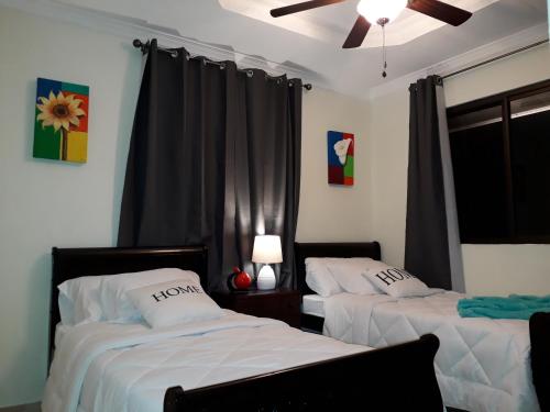 a bedroom with two beds and a ceiling fan at Casa Mirango Boquete in Boquete
