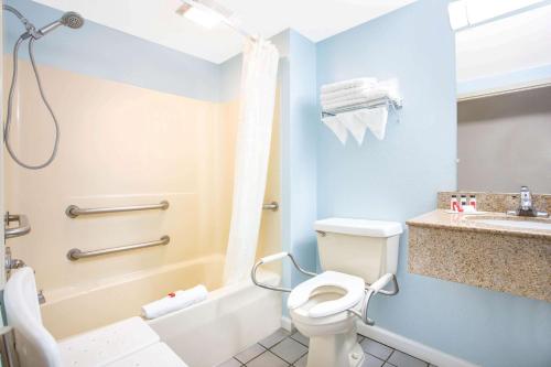 La salle de bains est pourvue de toilettes blanches et d'un lavabo. dans l'établissement Days Inn by Wyndham Lancaster PA Dutch Country, à Ronks