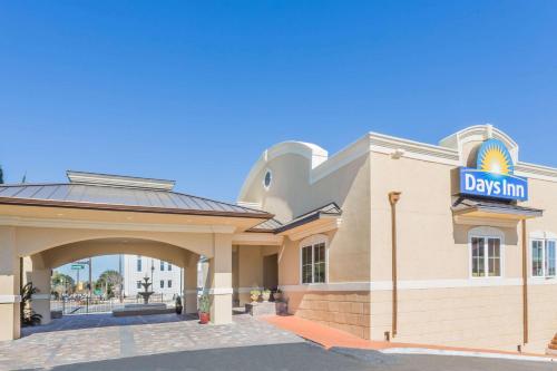 un cartello giornaliero per la locanda sul lato di un edificio di Days Inn by Wyndham Pensacola - Historic Downtown a Pensacola