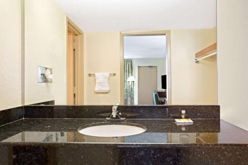 La salle de bains est pourvue d'un lavabo et d'un miroir. dans l'établissement Days Inn by Wyndham Orlando Airport Florida Mall, à Orlando