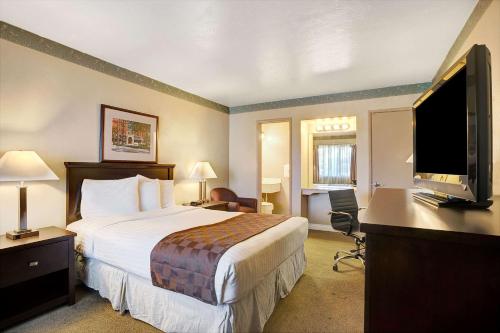 a hotel room with a bed and a flat screen tv at Travelodge by Wyndham Everett City Center in Everett