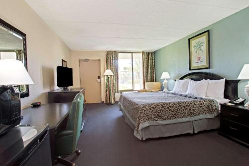 um quarto de hotel com uma cama e uma televisão em Days Inn by Wyndham Orlando Airport Florida Mall em Orlando