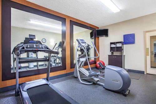 a room with a gym with a treadmill and a mirror at Baymont by Wyndham Saraland in Saraland