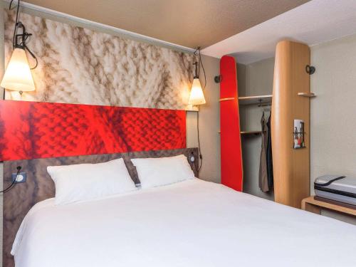 
a hotel room with a bed and a lamp at Ibis Hotel Köln Am Dom in Cologne
