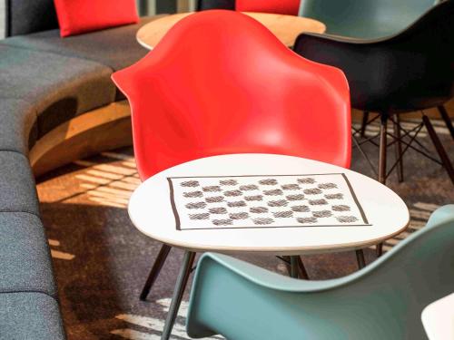 a table with a red chair with a chessboard on it at Ibis Brussels City Centre in Brussels
