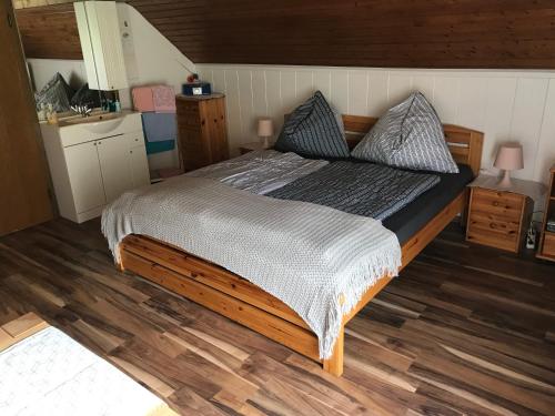 a bedroom with a large bed with a wooden floor at Wagnermoosgut in Bad Ischl