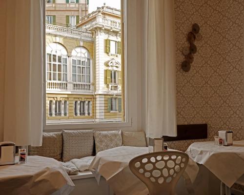 a room with two beds and a large window at Hotel Genova Liberty in Genoa
