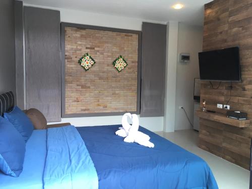 a room with a bed with a stuffed animal on it at Baan Fran Sim Da in Bang Tao Beach