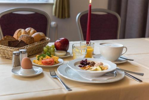 a table with plates of food and a basket of bread at Hotel Europa in Münster